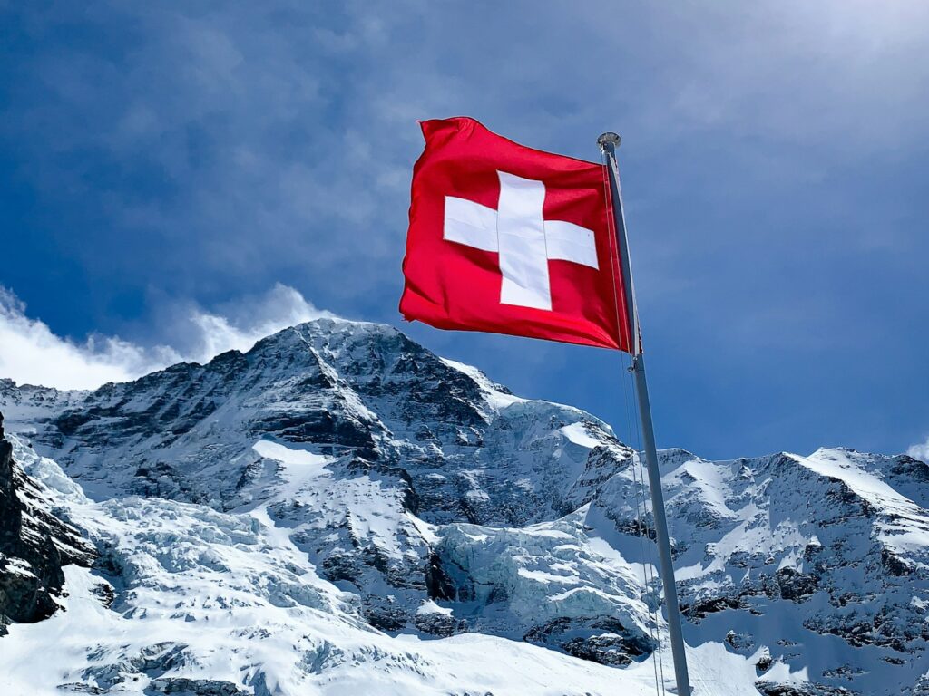 Drapeau suisse avec fond de montagnes enneigées- marché suisse - Epsimas